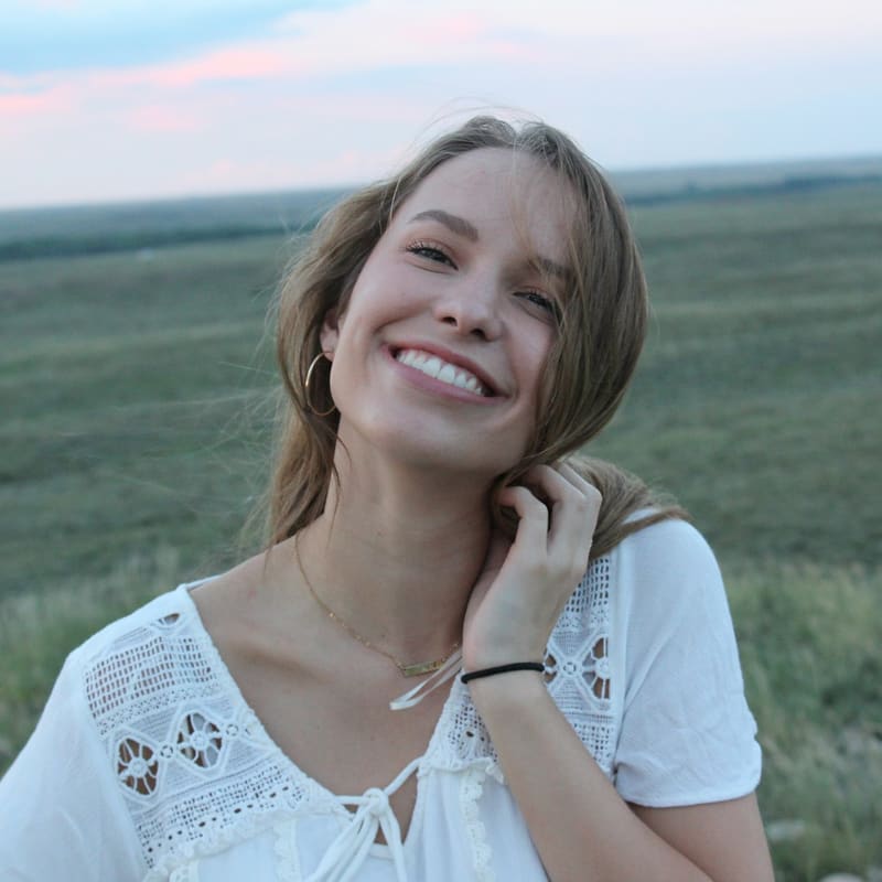 A woman smiling outdoors in the evening light