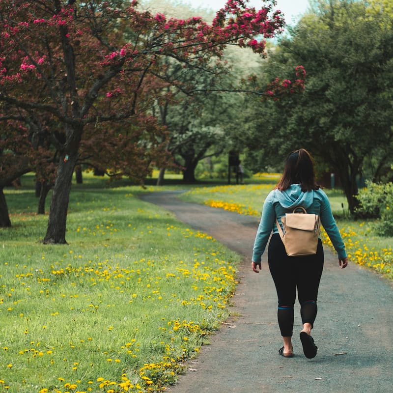 A woman walking along a path in a park